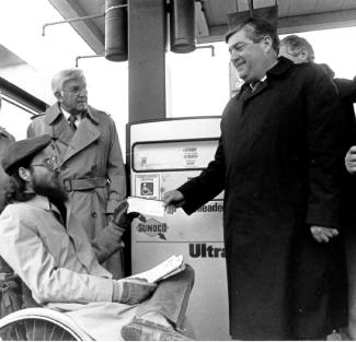 Bob Cooper talking to a State Leader in front of a gas pump